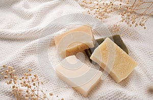 Handmade soap bars on white towel top view with copy space