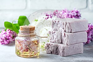Handmade soap, Glass jar with fragrant oil and lilac flowers for spa and aromatherapy. photo