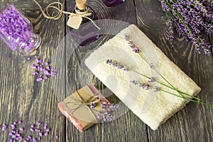 Handmade soap, sea salt and lavender tincture, towel on wooden surface