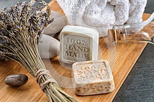 Handmade soaps with lavender bunch and stones on wooden board, product of cosmetics or body care