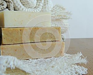 Handmade spa bath soap on white handmade linen waffle texture wash cloth, towel, wooden background.