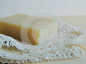 Handmade spa bath soap on white handmade linen waffle texture wash cloth, towel, wooden background.