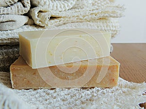 Handmade spa bath soap on white handmade linen waffle texture wash cloth, towel, wooden background.