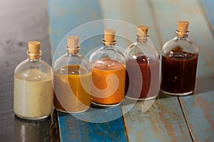 Handmade spicy sauces in glass bottles with cork photo