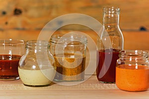 Handmade spicy sauces in glass jars on a colored wooden base - Salsas picantes hechas artesanalmente en frascos de vidrio sobre photo