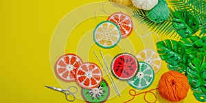 Handmade summer background. Slices of crocheted fruits, traditional accessory, bright yellow color