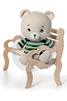 Handmade toy beige bear sit on the bench