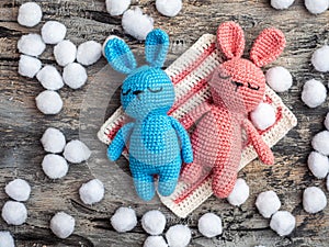 Handmade toys, amigurumi bunnies blue and pink on a gray background