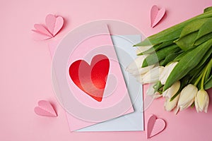 Handmade Valentine greeting card with white tulips on pink background with paper hearts. Valentine\'s Day letter