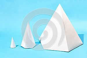 handmade various paper cone and pyramids on blue