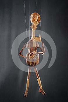 Handmade violoncello or violin like puppet on black background