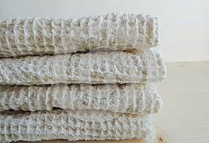 Handmade waffle texture linen cotton towels, wash cloth, kitchen towels, hand towels, bath towels on wooden background. Gift. Food