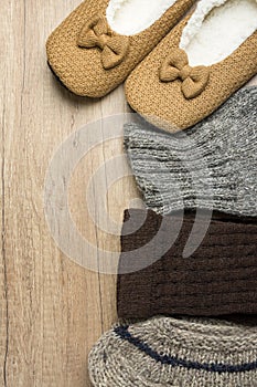 Handmade Warm Knitted Socks From Rough Wool Yarn Fluffy Fir Slippers on Wood Background. Winter Autumn Eco Fashion