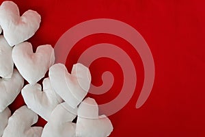 Handmade white fabric hearts on red background - image