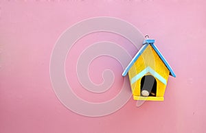 Handmade wood home on pink wall