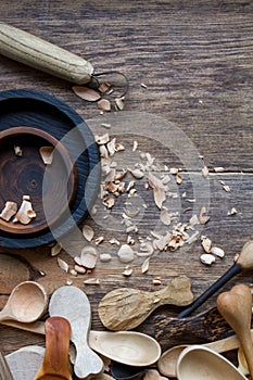 Handmade wooden kitchen utensils, top view lot of billets, spoons and plates on wooden table, selective focus