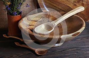 Handmade wooden utensils on the kitchen table. Wooden plate, bowl, dishes and spoons on the table