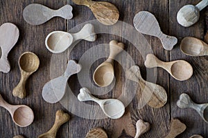 Handmade wooden utensils, top view lot of billets and spoons on wooden table, selective focus