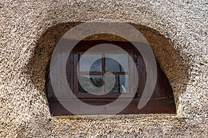 Handmade wooden window of a thatched roof house