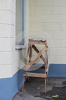 Handmade work bench on a construction site against a beige and blue plastered walls and window.