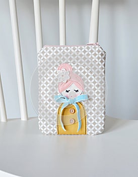 Handmade zipper pouch with cute doll applique on chair