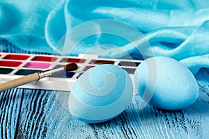 Handmaid blue paint easter egg on table with scarf