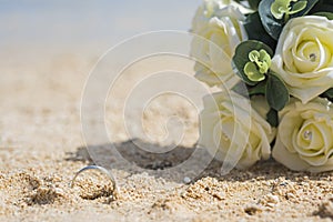 Handprint in sand of tropical beach with wedding ring abstract concept