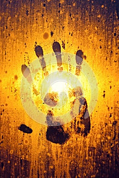 Handprint on steamy window glass