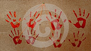 handprints of red, bloody color, on a cork board photo