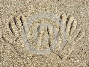 Handprints on a sand.