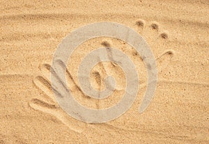 Handprints on sand