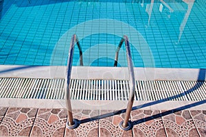 Handrail on the pool. Swimming pool with stair closeup.