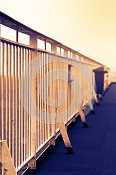 Handrails on the promenade deck of a large cruise ship in warm sunset lighting