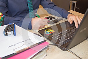 Hands of accountant with calculator and pen. Accounting background. Businessman using a calculator to calculate the numbers