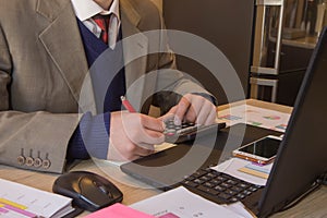 Hands of accountant with calculator and pen. Accounting background. Businessman using a calculator to calculate the numbers