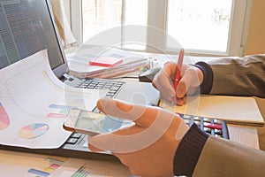 Hands of accountant with calculator and pen. Accounting background. Businessman using a calculator to calculate the numbers