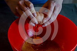 hands adding egg to fresh white cheese being whipped together to make cheesecake cream