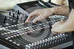 Hands adjust controls on sound mixer 3