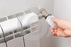 Hands adjusting modern radiator thermosta
