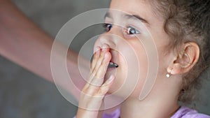 The hands of an adult pull the thread tied to the child`s tooth. Successful attempt to remove a tooth. Pull out the