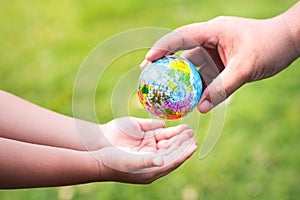 The hands of adults are passing the world to the hands of children, to continue to care and heal our planet.