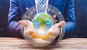 hands of a african american child holding crystal glowing globe planet earth at a sunny green meadow background copyspace taking