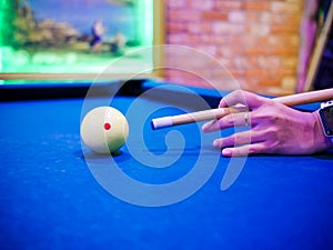 Hands aiming white ball to shot close up