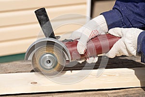 Hands With Angle Grinder Grind Wooden Board Close-Up