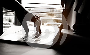 hands of anonymous hackers typing code on keyboard of laptop for