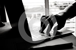 hands of anonymous hackers typing code on keyboard of laptop for