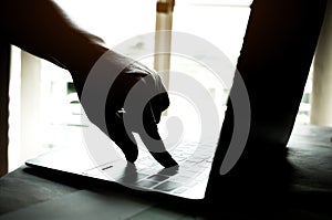 hands of anonymous hackers typing code on keyboard of laptop for