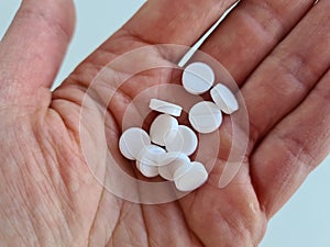 Hands with antibacterial medicine and white pills closeup