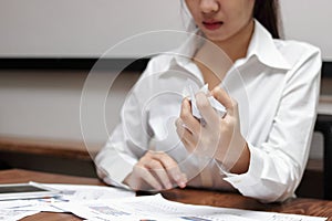 Hands of anxiety businesswoman holding crumpled paper on workplace in office. Failure and tired business concept.