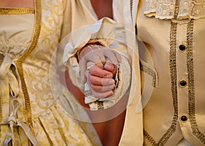 hands of the aristocratic man and woman during the ceremony with luxurious historical period clothes
